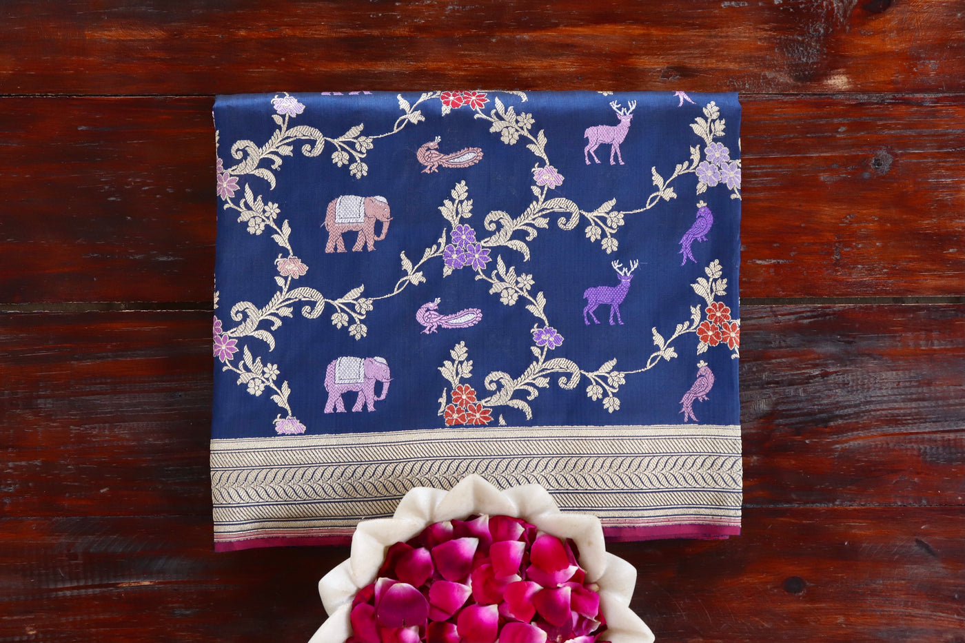 Royal Blue pure silk Banarasi saree with scrolling vines and florals in continuous Jangla layout, draped for the camera.