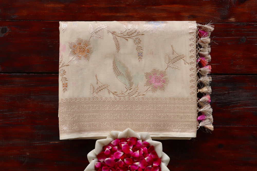 Ivory Organza silk Banarasi saree with scrolling vines and florals in continuous Jangla layout, draped for the camera.