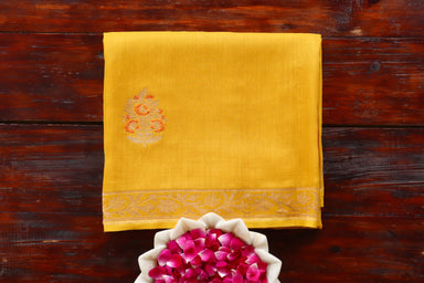 Yellow Munga silk Banarasi saree with thread-by-thread motifs, draped for the camera.