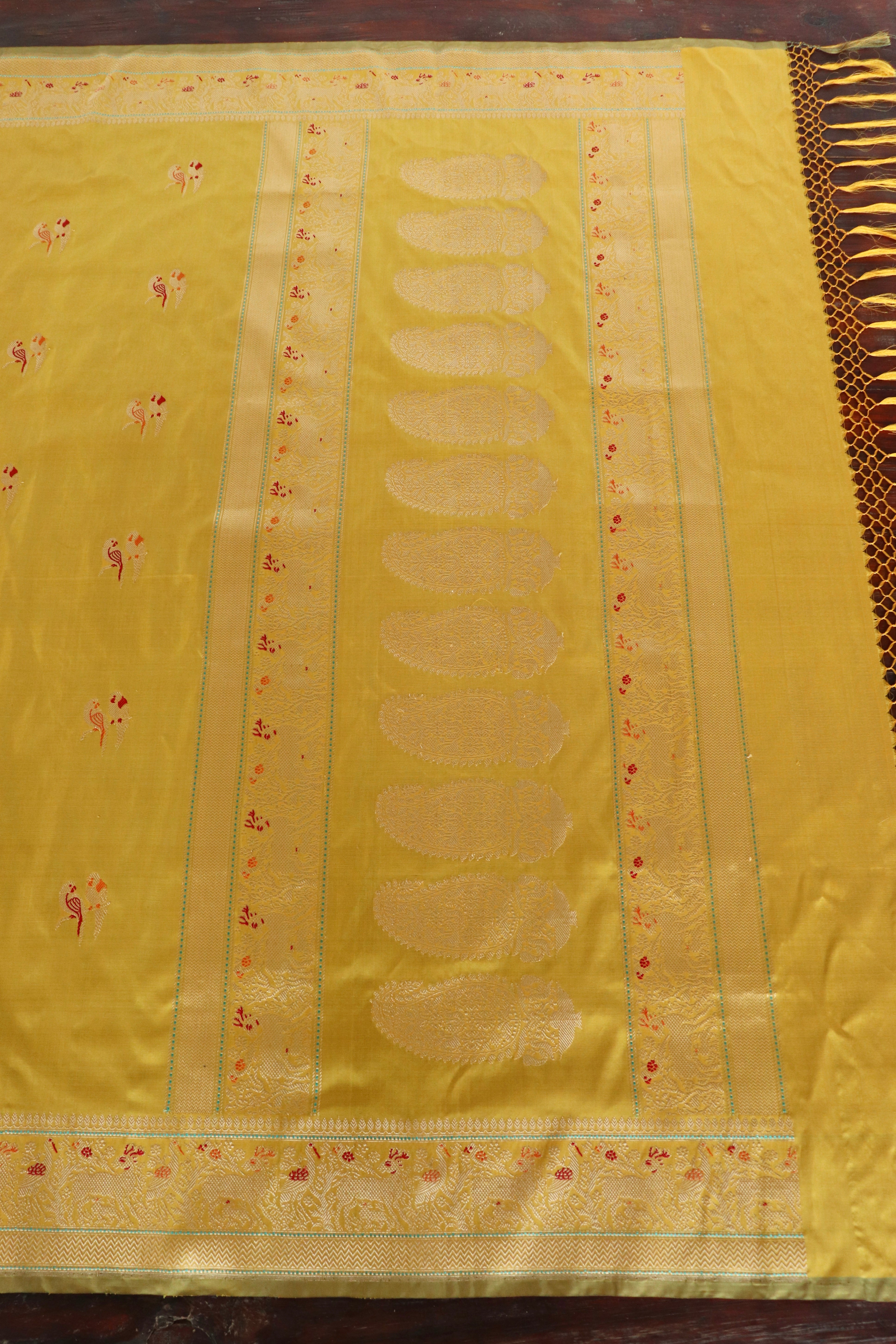 A haldi-yellow Banarasi with woven kalga motifs, laid flat