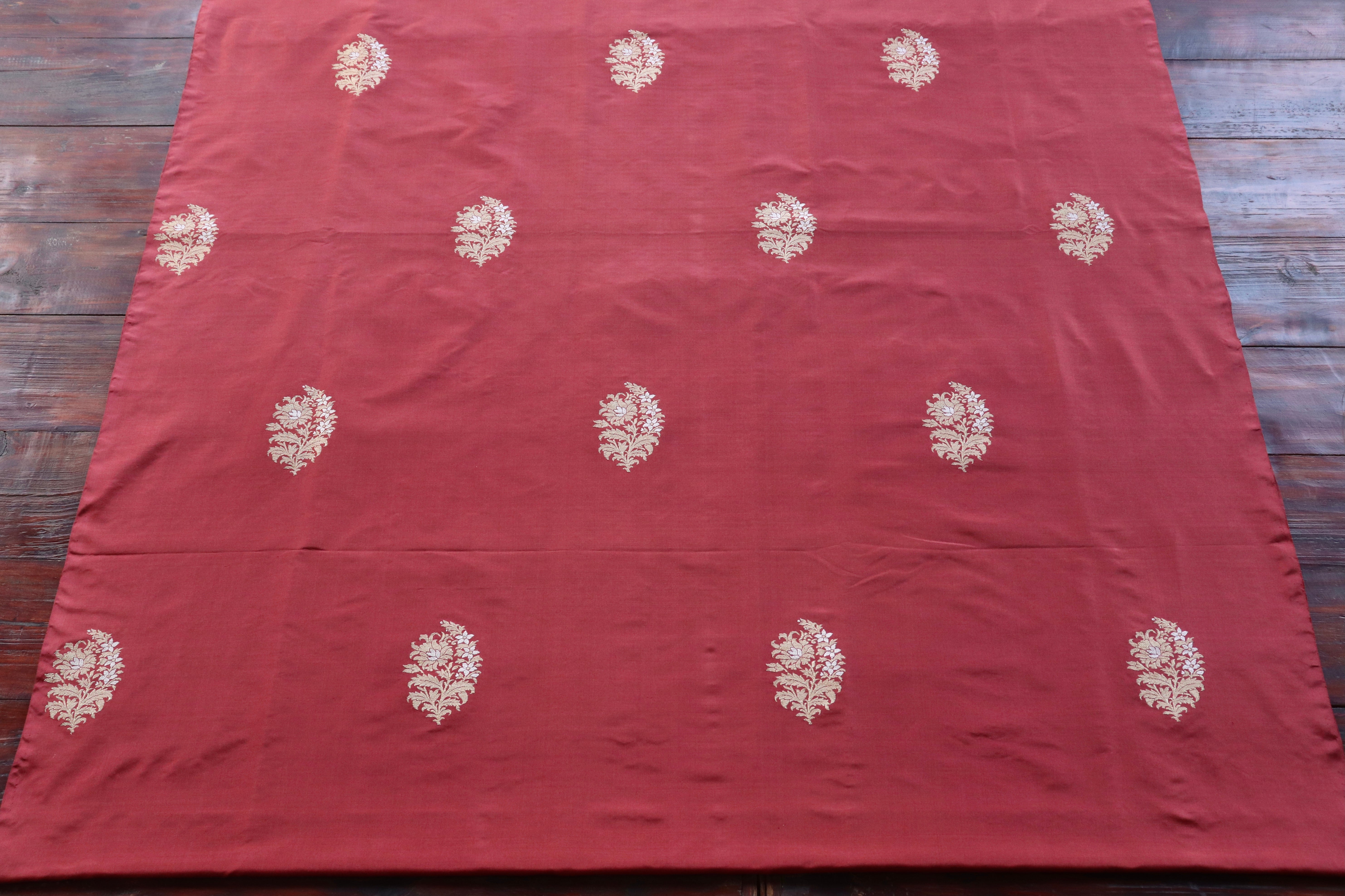 Gold butas across a deep maroon katan silk field