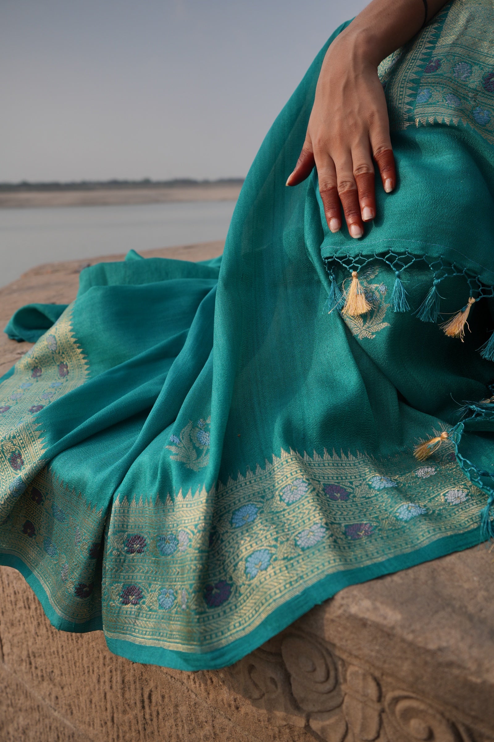 A jade Banarasi at the edge of the river in evening light